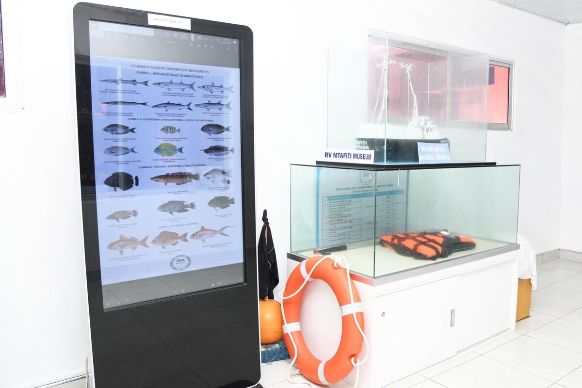 Interactive touchscreen fish-identification display beside a holding tank